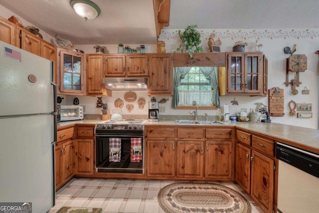 1203 Spring Cove Rd, Blairsville, GA 30512 - kitchen with white appliances, under cabinet range hood, light countertops, and brown cabinetry