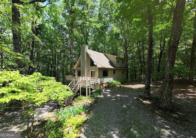 1203 Spring Cove Rd, Blairsville, GA 30512 - rustic home with a chimney, stairway, a deck, gravel driveway, and a wooded view
