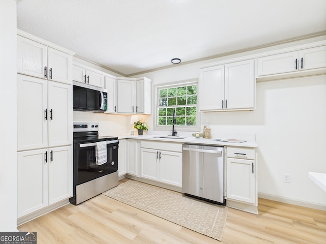 6417 Carey Pl, Macon, GA 31216 - kitchen featuring appliances with stainless steel finishes, light wood-type flooring, white cabinetry, and light countertops