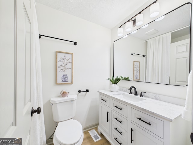 6417 Carey Pl, Macon, GA 31216 - full bath with vanity, wood finished floors, a textured ceiling, and a shower with curtain