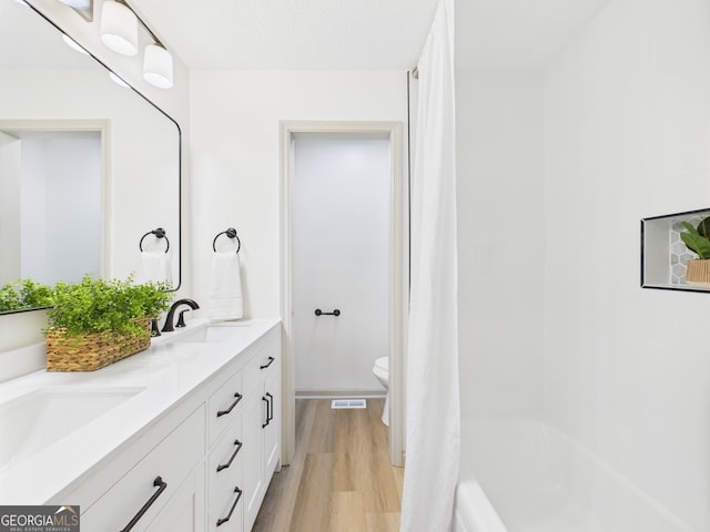 6417 Carey Pl, Macon, GA 31216 - full bathroom featuring wood finished floors, double vanity, and shower / bathtub combination with curtain