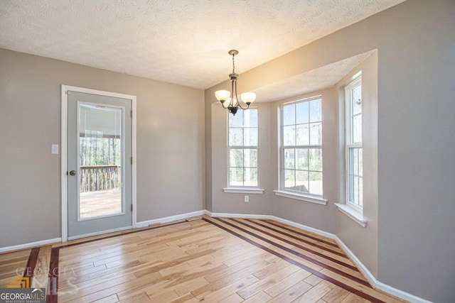 48 Glenhaven Ct, Douglasville, GA 30134 - unfurnished dining area with light wood-style floors, a chandelier, and a textured ceiling