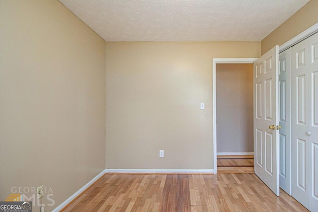 48 Glenhaven Ct, Douglasville, GA 30134 - unfurnished bedroom featuring light wood-style flooring, a textured ceiling, and a closet