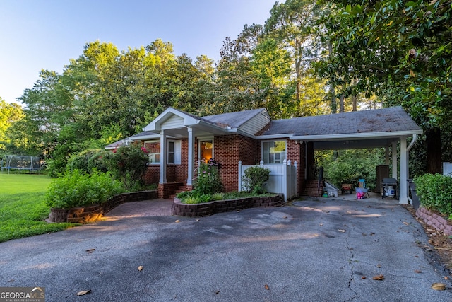 8815 Campbellton St, Douglasville, GA 30134 - ranch-style home featuring driveway, an attached carport, a trampoline, brick siding, and a front lawn