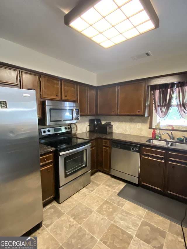 110 Waverly Way, Lagrange, GA 30240 - kitchen with stainless steel appliances, dark brown cabinetry, and decorative backsplash