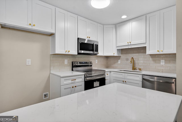 116 Preston Pl, Lagrange, GA 30241 - kitchen featuring appliances with stainless steel finishes, decorative backsplash, white cabinets, light stone countertops, and recessed lighting