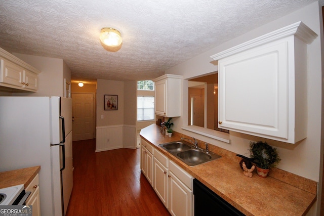 555 Flintlock Dr, Dacula, GA 30019 - kitchen featuring dark wood-style floors, wainscoting, freestanding refrigerator, white cabinets, and a textured ceiling