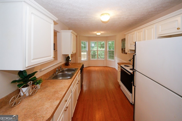 555 Flintlock Dr, Dacula, GA 30019 - kitchen featuring white appliances, wood finished floors, white cabinets, light countertops, and a textured ceiling