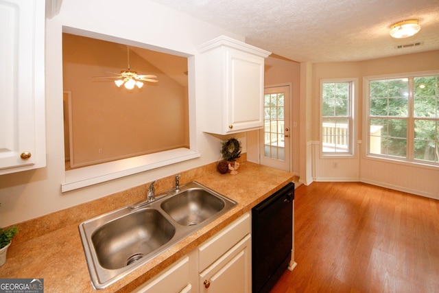 555 Flintlock Dr, Dacula, GA 30019 - kitchen featuring black dishwasher, wood finished floors, light countertops, white cabinets, and a textured ceiling