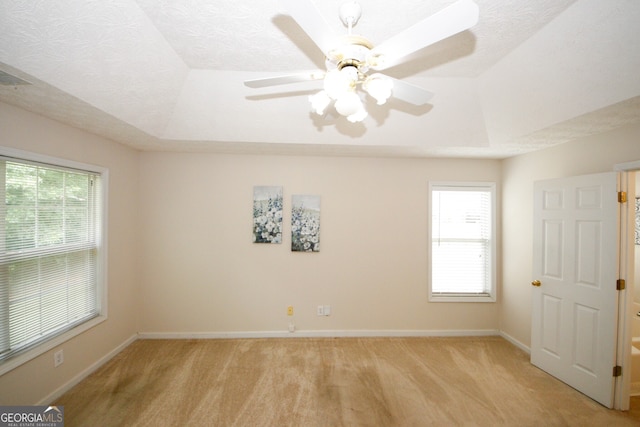 555 Flintlock Dr, Dacula, GA 30019 - empty room featuring a tray ceiling, light carpet, and a ceiling fan