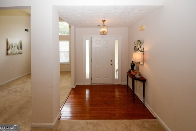 555 Flintlock Dr, Dacula, GA 30019 - entrance foyer with carpet flooring, wood finished floors, a chandelier, and a textured ceiling