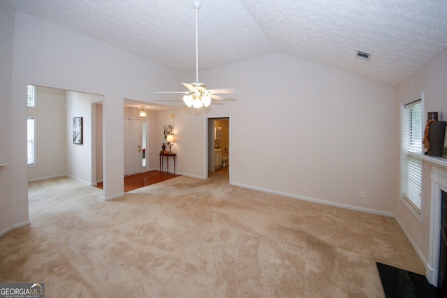 555 Flintlock Dr, Dacula, GA 30019 - unfurnished living room featuring lofted ceiling, light carpet, ceiling fan, a textured ceiling, and a fireplace