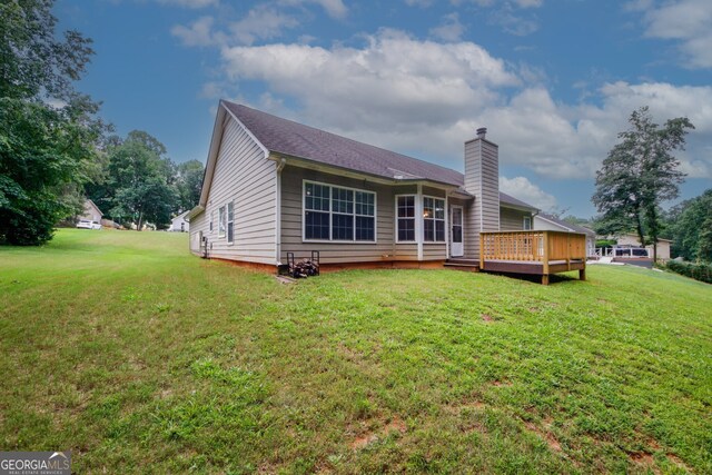 555 Flintlock Dr, Dacula, GA 30019 - rear view of property with a deck, a chimney, and a lawn