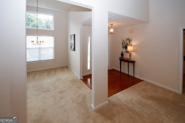 555 Flintlock Dr, Dacula, GA 30019 - corridor with carpet flooring, a chandelier, and high vaulted ceiling