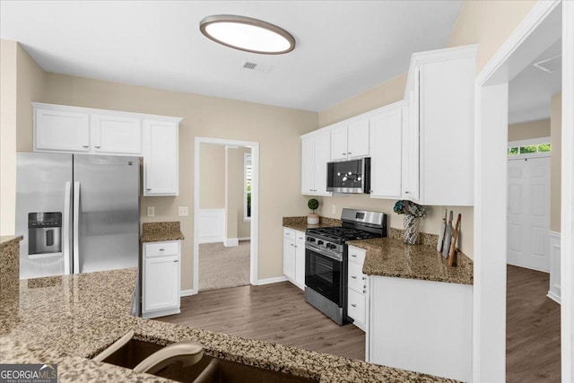 3559 Reservoir Pass, Acworth, GA 30101 - kitchen with appliances with stainless steel finishes, wood finished floors, white cabinetry, and stone countertops