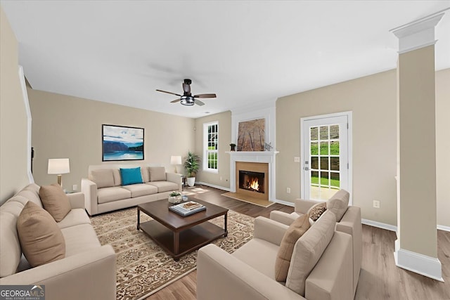 3559 Reservoir Pass, Acworth, GA 30101 - living room featuring wood finished floors, a fireplace with flush hearth, a ceiling fan, and decorative columns