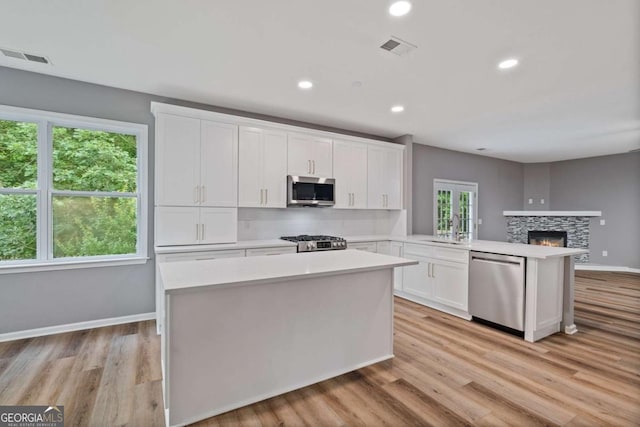 950 Mill Creek Ave, Canton, GA 30115 - kitchen with appliances with stainless steel finishes, a peninsula, light countertops, white cabinetry, and recessed lighting
