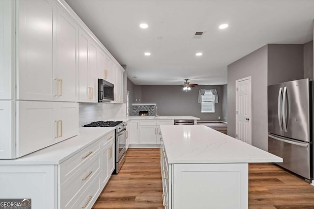 950 Mill Creek Ave, Canton, GA 30115 - kitchen featuring appliances with stainless steel finishes, a kitchen island, recessed lighting, ceiling fan, and a peninsula