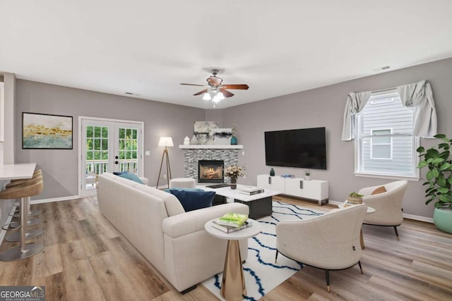950 Mill Creek Ave, Canton, GA 30115 - living room featuring light wood-style floors, french doors, ceiling fan, and a fireplace