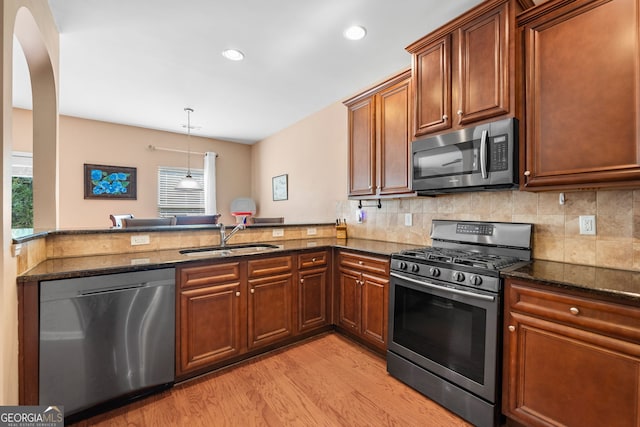 305 Hidden Creek Ln, Canton, GA 30114 - kitchen featuring stainless steel appliances, light wood-style floors, dark stone countertops, tasteful backsplash, and recessed lighting