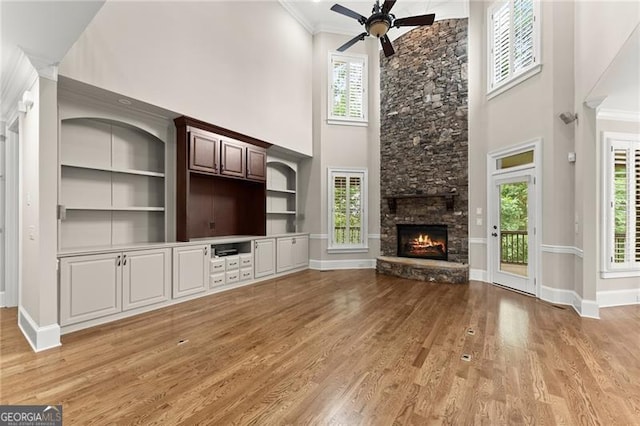 3311 Marina View Way, Gainesville, GA 30506 - unfurnished living room with a high ceiling, a ceiling fan, plenty of natural light, light wood-style flooring, and a stone fireplace