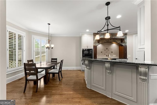3311 Marina View Way, Gainesville, GA 30506 - kitchen featuring a chandelier, black microwave, tasteful backsplash, ornamental molding, and dark stone counters
