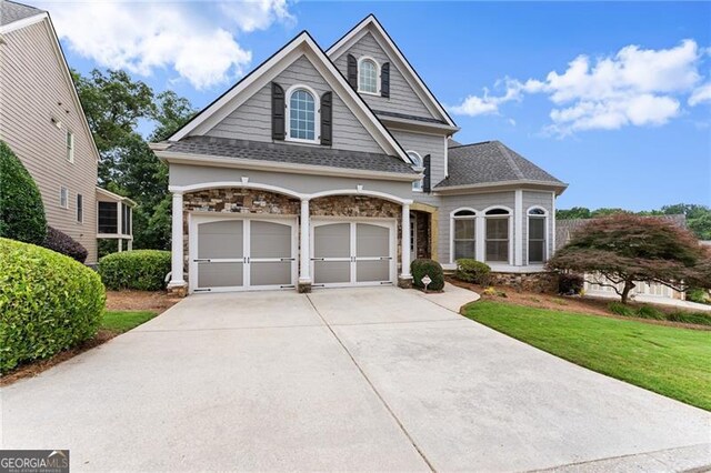 3311 Marina View Way, Gainesville, GA 30506 - view of front of property with driveway, stone siding, a garage, a front lawn, and roof with shingles