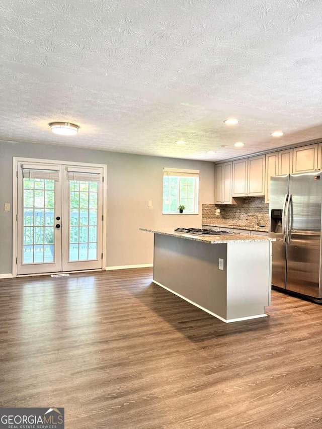 3544 Citrus Dr, Duluth, GA 30096 - kitchen featuring stainless steel appliances, wood finished floors, a textured ceiling, backsplash, and a center island