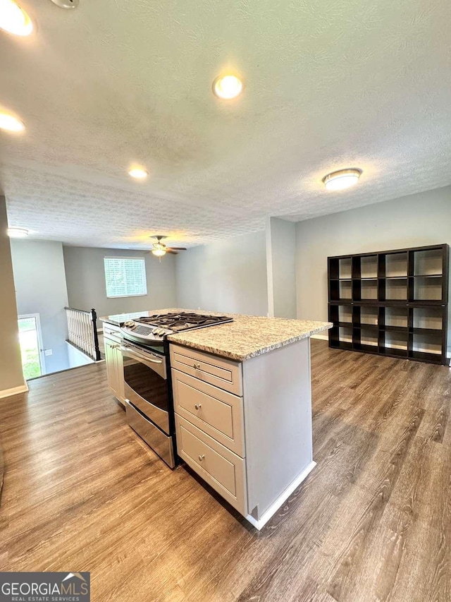 3544 Citrus Dr, Duluth, GA 30096 - kitchen with stainless steel range with gas cooktop, light wood-type flooring, a textured ceiling, a ceiling fan, and a kitchen island