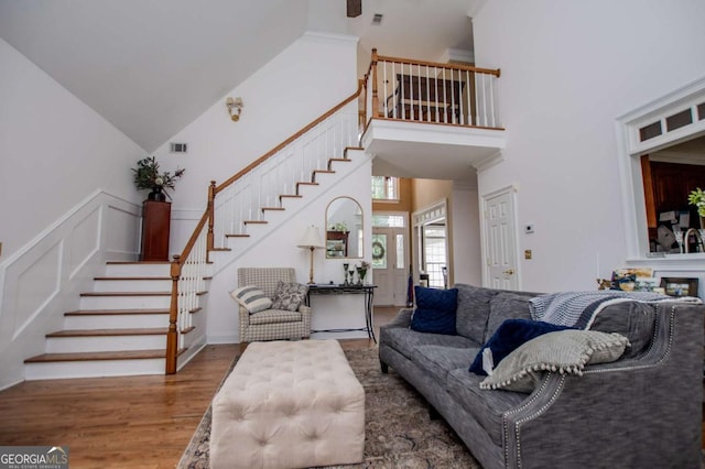 204 Pinehurst Way, Carrollton, GA 30116 - living area with stairway, a high ceiling, wood finished floors, and a wainscoted wall