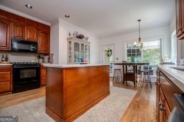 204 Pinehurst Way, Carrollton, GA 30116 - kitchen with black appliances, light countertops, light wood-style flooring, plenty of natural light, and ornamental molding