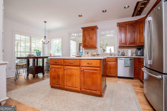 204 Pinehurst Way, Carrollton, GA 30116 - kitchen featuring stainless steel appliances, brown cabinets, light wood-style floors, ornamental molding, and recessed lighting