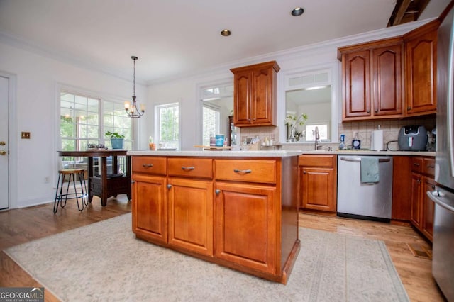 204 Pinehurst Way, Carrollton, GA 30116 - kitchen with stainless steel dishwasher, light wood-style flooring, decorative backsplash, light countertops, and crown molding