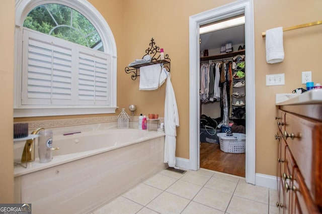 204 Pinehurst Way, Carrollton, GA 30116 - bathroom featuring a garden tub, tile patterned flooring, vanity, and a walk in closet