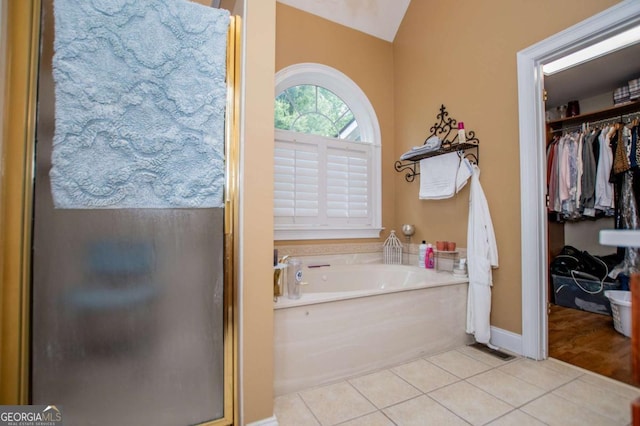 204 Pinehurst Way, Carrollton, GA 30116 - bathroom featuring tile patterned flooring, a garden tub, a shower stall, a walk in closet, and vaulted ceiling