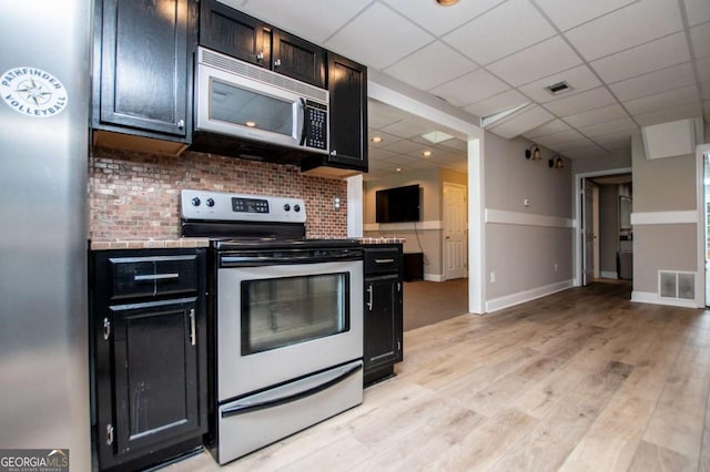 204 Pinehurst Way, Carrollton, GA 30116 - kitchen featuring stainless steel appliances, dark cabinetry, light wood-type flooring, and light countertops