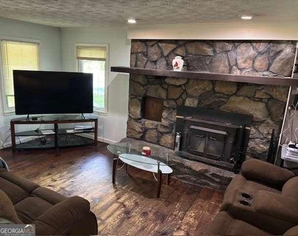 2497 Old Jackson Rd, Locust Grove, GA 30248 - living area featuring wood-type flooring, a textured ceiling, and a fireplace