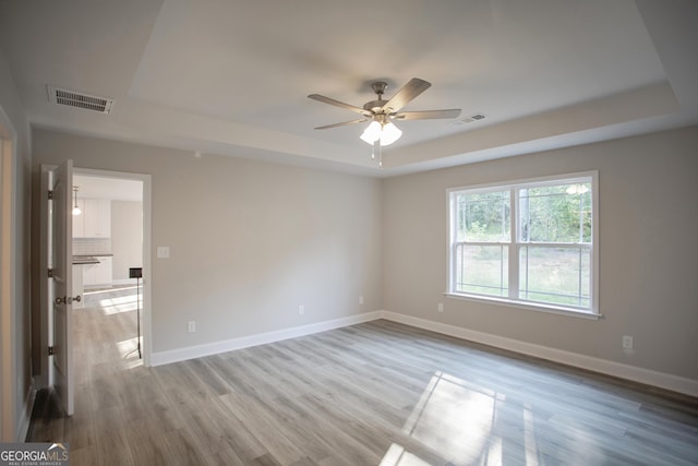 266 Patillo Rd, Jackson, GA 30233 - empty room featuring a tray ceiling, ceiling fan, and light wood finished floors