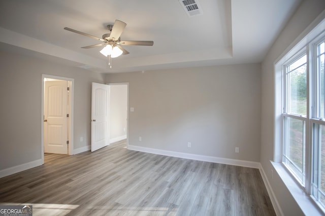 266 Patillo Rd, Jackson, GA 30233 - unfurnished bedroom featuring a raised ceiling, multiple windows, and wood finished floors