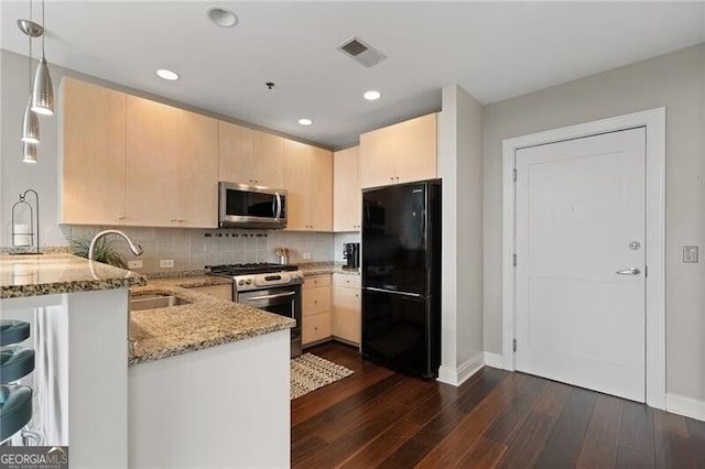 905 Juniper St NE Unit 701, Atlanta, GA 30309 - kitchen with appliances with stainless steel finishes, a peninsula, light brown cabinetry, light stone counters, and dark wood finished floors