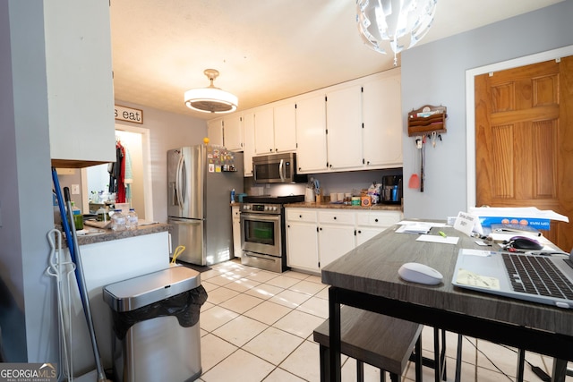 1858 Mcconnell Rd, Grayson, GA 30017 - kitchen featuring stainless steel appliances, white cabinets, light tile patterned floors, and dark countertops