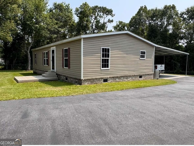 601 Auburn Rd, Glennville, GA 30427 - view of home's exterior with crawl space, a carport, asphalt driveway, and a lawn