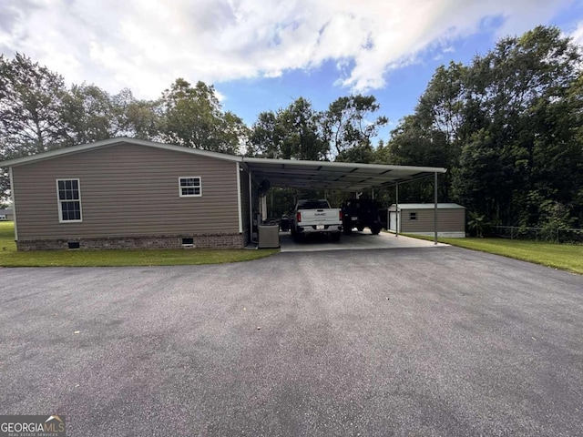 601 Auburn Rd, Glennville, GA 30427 - view of side of home with driveway, crawl space, a carport, a storage shed, and a yard