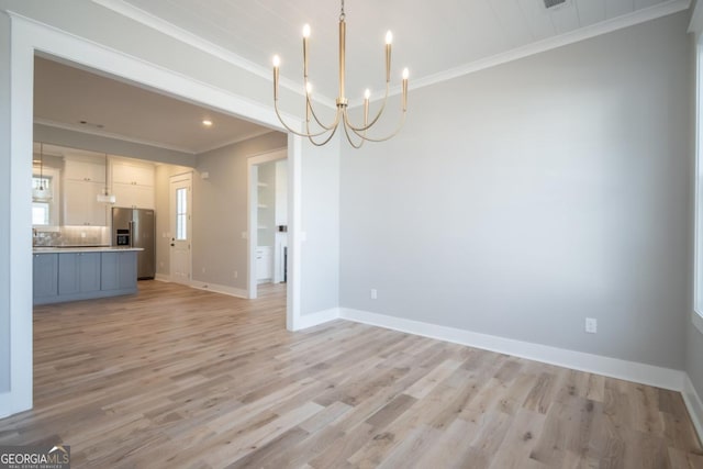 145 Holmes Ave, Athens, GA 30606 - unfurnished living room with crown molding, a chandelier, and light wood-type flooring