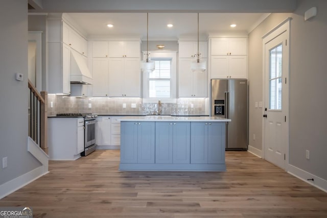 145 Holmes Ave, Athens, GA 30606 - kitchen featuring stainless steel appliances, a center island, under cabinet range hood, white cabinets, and recessed lighting