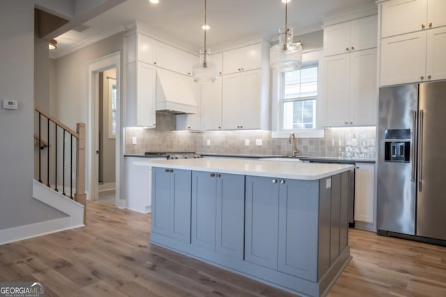 145 Holmes Ave, Athens, GA 30606 - kitchen with high end refrigerator, crown molding, a kitchen island, backsplash, and wood finished floors