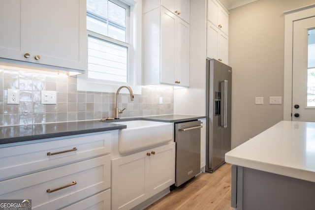 145 Holmes Ave, Athens, GA 30606 - kitchen featuring stainless steel appliances, backsplash, light wood-style floors, white cabinets, and dark countertops