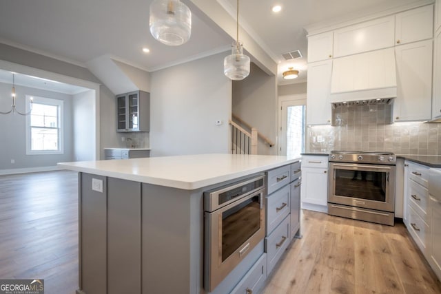 145 Holmes Ave, Athens, GA 30606 - kitchen with stainless steel electric stove, tasteful backsplash, gray cabinetry, light wood finished floors, and crown molding