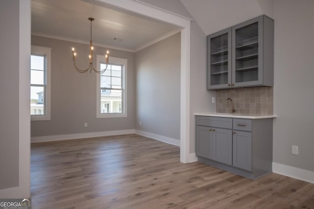 145 Holmes Ave, Athens, GA 30606 - unfurnished dining area featuring a chandelier, light wood-style floors, ornamental molding, and wet bar