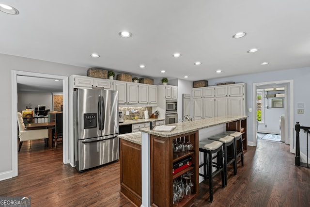 3648 Sope Creek Farm SE, Marietta, GA 30067 - kitchen with stainless steel appliances, light stone counters, white cabinets, decorative backsplash, and dark wood-type flooring